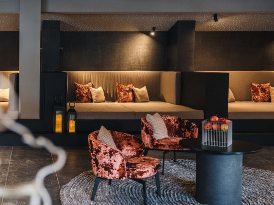 Delicious indulgence in a glass Modern lounge with velvet chairs and large sofas in warm ambient lighting