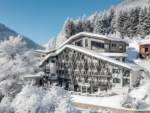 Info on hikes in St. Anton am Arlberg and more Hotel with snow-covered roof in winter mountain scene
