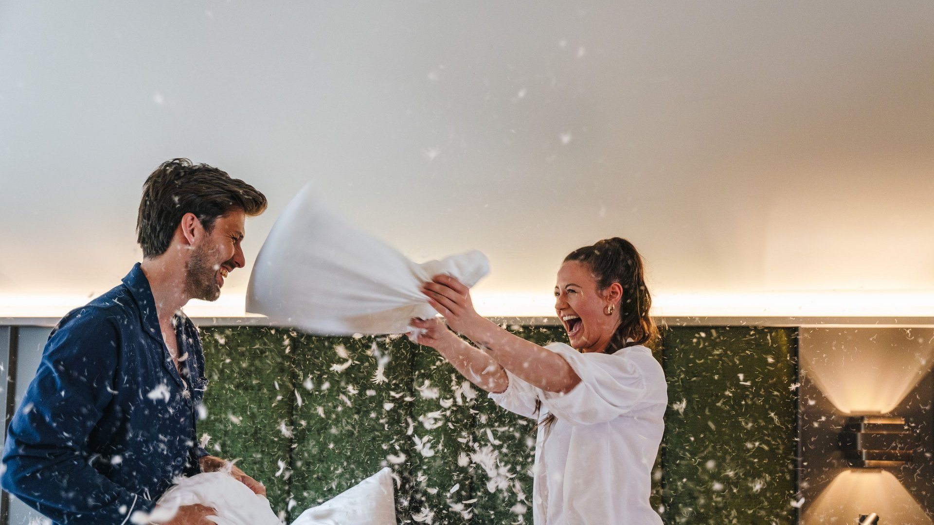Offers at Arpuria – your hotel in St. Anton am Arlberg Couple having a playful pillow fight in the bedroom