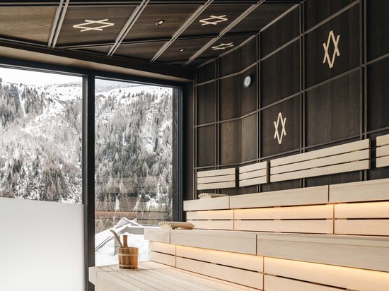 Winter hiking at Mt Arlberg Modern sauna with view of snowy mountains through large window