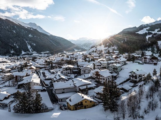 Delicious indulgence in a glass Sunrise over snow-covered mountain village in valley