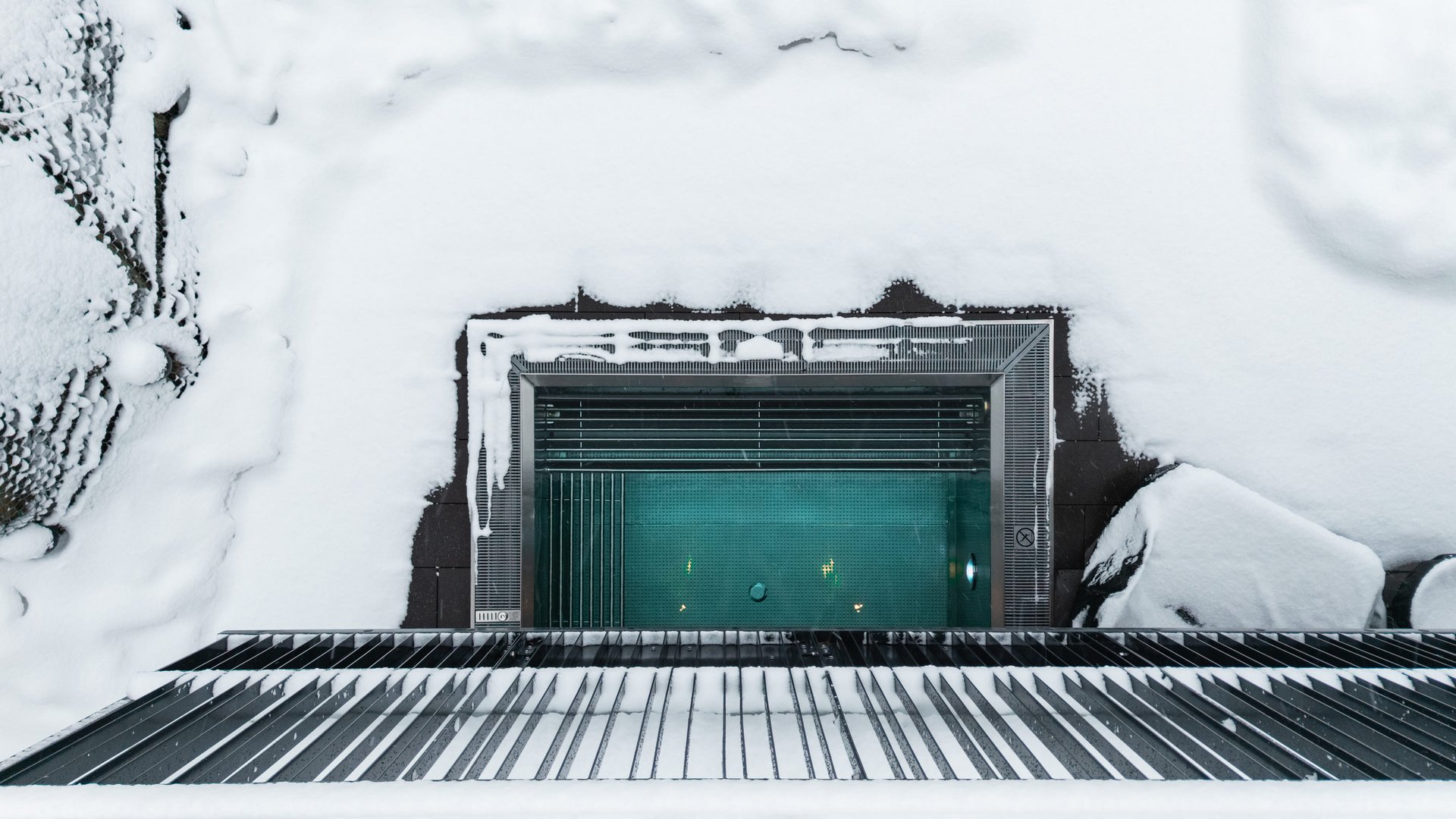 Reine Urlaubsfreude in Ihrem Hotel in St. Anton Blick von oben auf ein beheiztes Schwimmbecken im Schnee