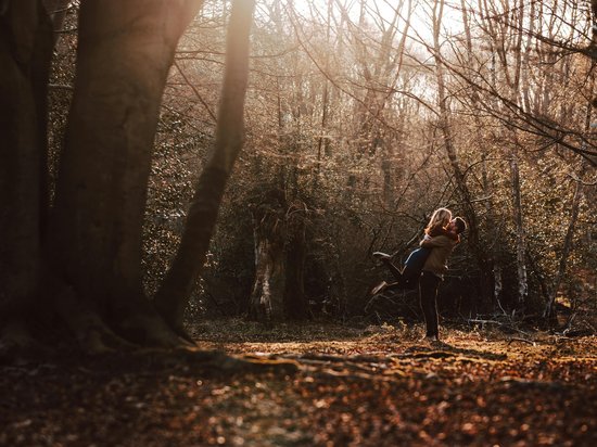 Delicious indulgence in a glass Couple embracing happily in autumn forest with sunlight filtering through trees