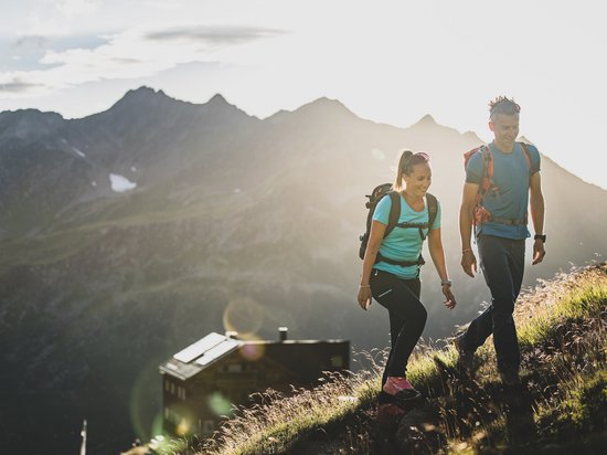 Adventure in harmony with nature Couple hiking in the mountains at sunset with backpacks